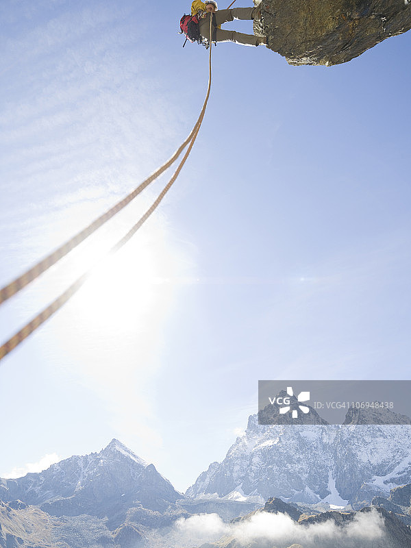 登山者从山上的悬崖上绳降图片素材