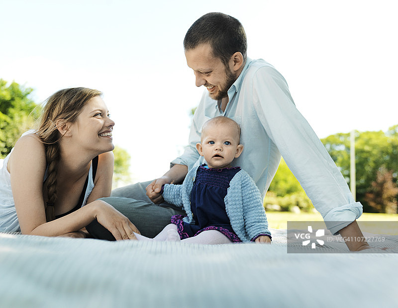 夫妇和女婴在毯子上图片素材