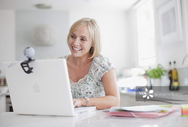 在笔记本电脑上进行视频聊天的微笑女人图片素材