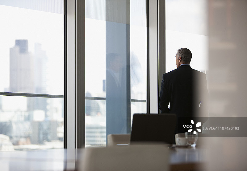 商人望向会议室窗外图片素材