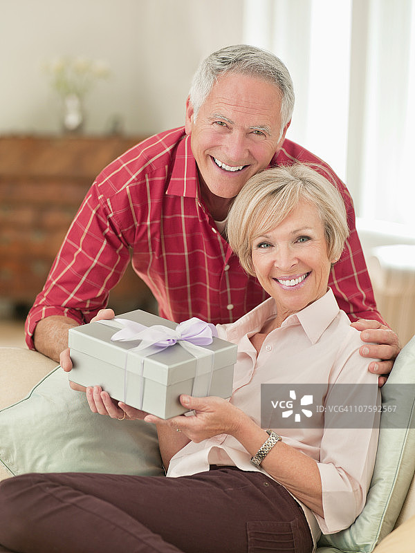 在沙发上交换礼物的夫妇，肖像图片素材
