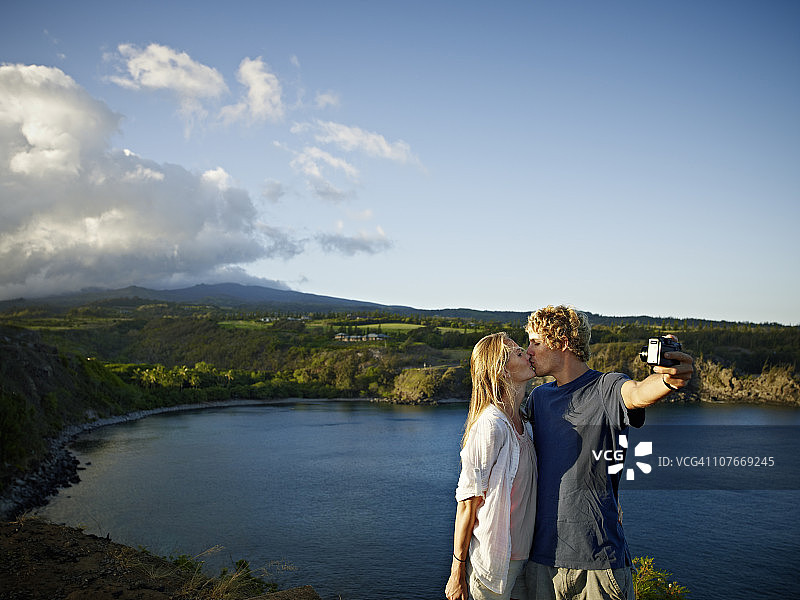 情侣在观景台用数码相机拍照图片素材