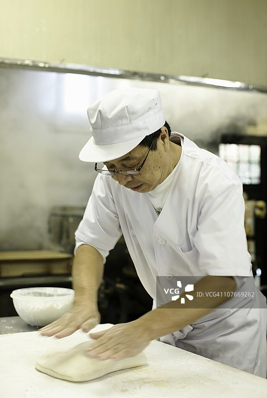厨师在商业厨房揉搓年糕图片素材