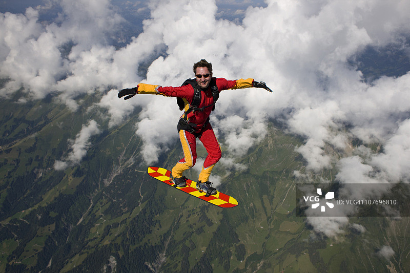 跳伞者脚踩滑板飞翔在蓝天图片素材