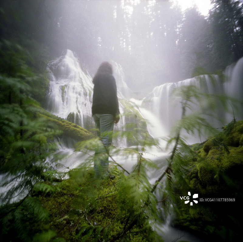 站在瀑布天堂的女孩图片素材