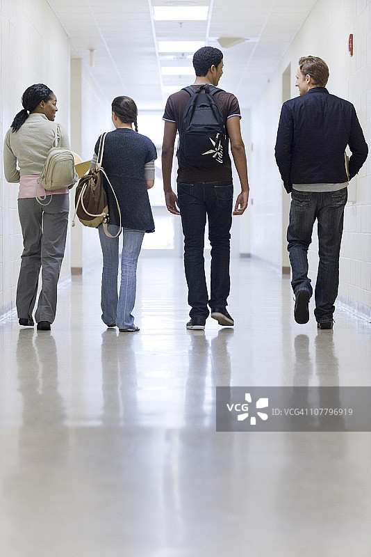 高中生走在学校走廊上，后视图图片素材