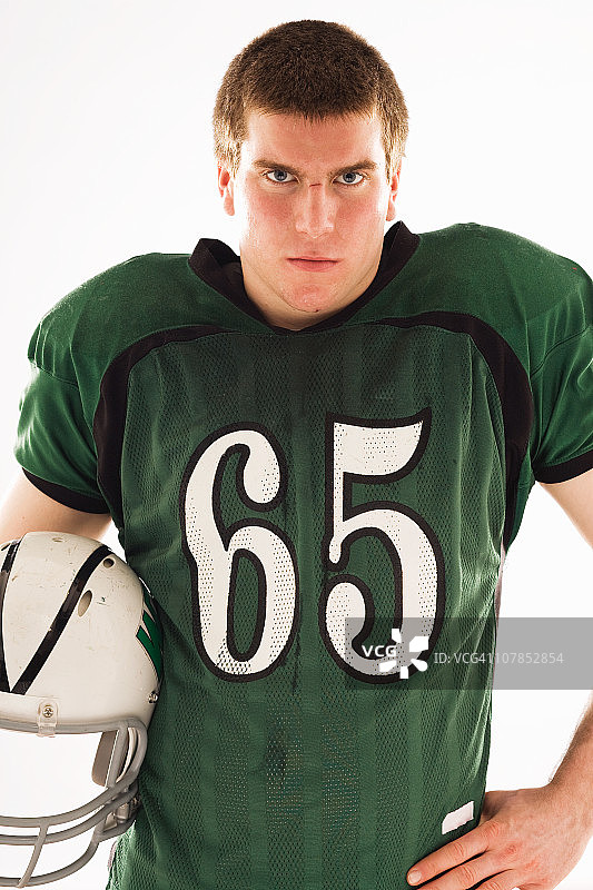 手持头盔的青少年足球运动员肖像图片素材