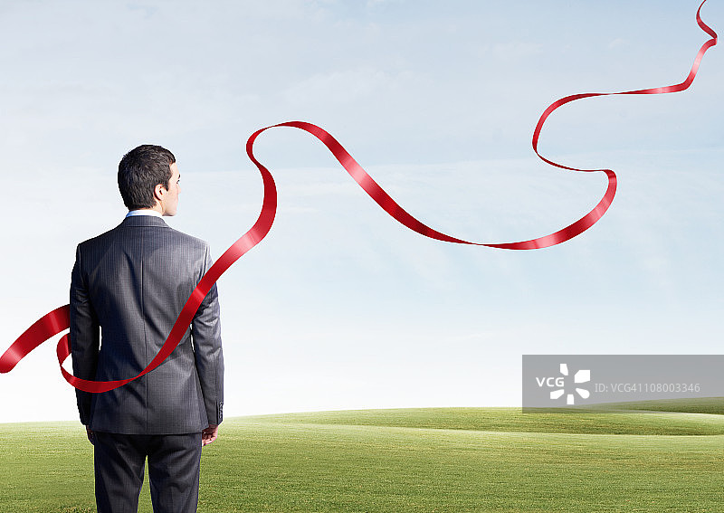 商人看着漂浮的红色丝带图片素材