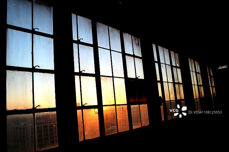 夕阳穿过的工业窗格图片素材