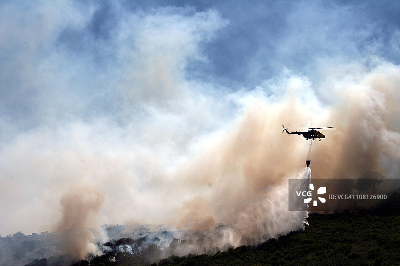 直升机在森林火灾上洒水图片素材