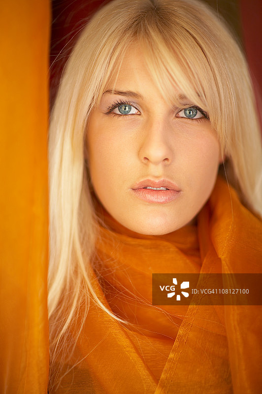 佩戴橙色披肩围巾的年轻女人图片素材