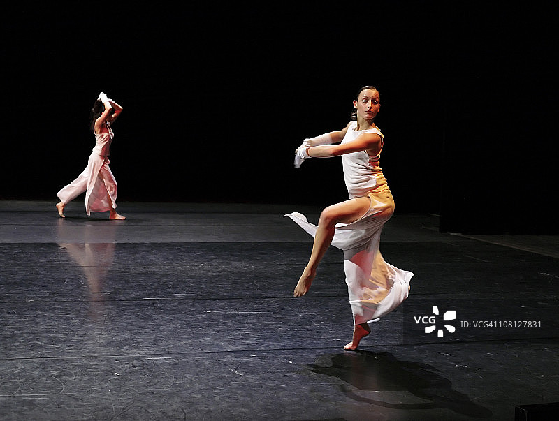 身穿白色芭蕾舞裙的芭蕾舞演员正在旋转图片素材