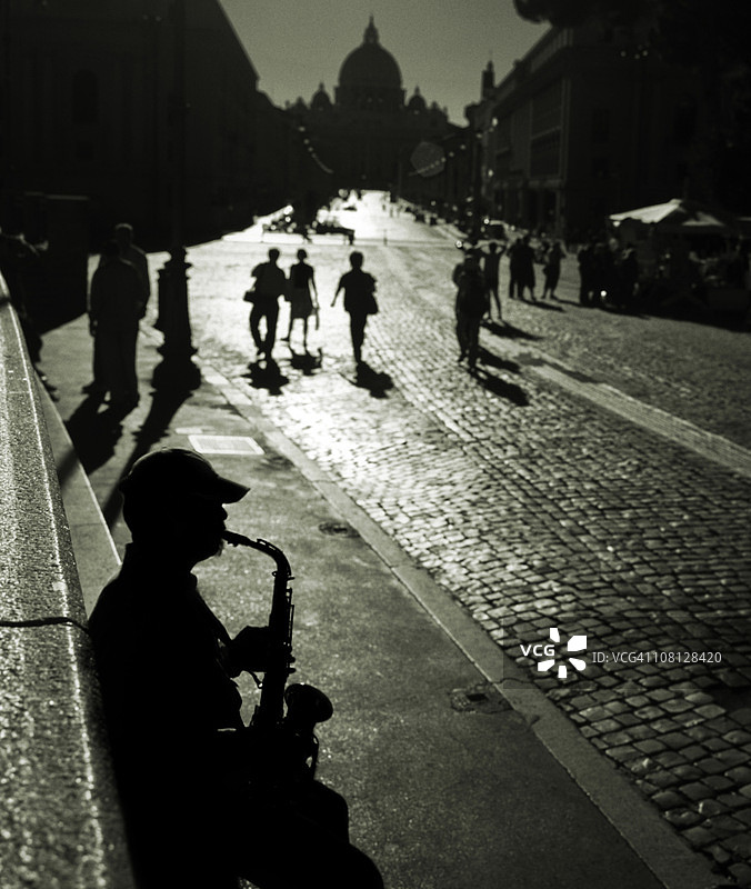 意大利罗马圣彼得大教堂的萨克斯演奏者剪影图片素材