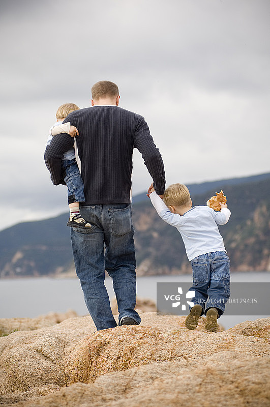 父子在海边攀岩图片素材
