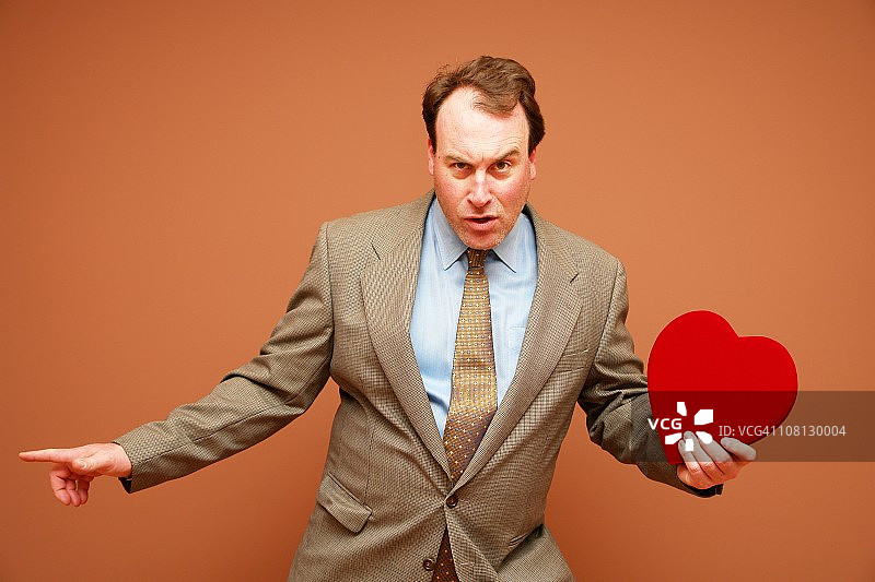 手持情人节红心的商人图片素材