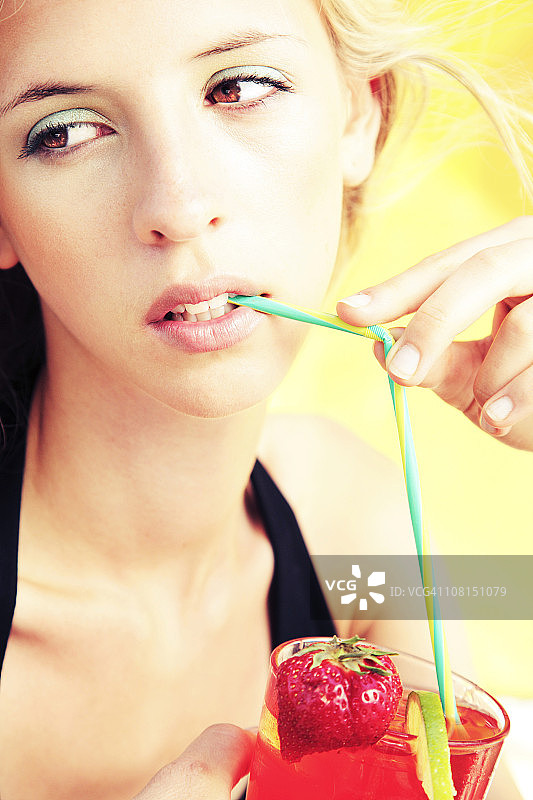 年轻女子品尝鸡尾酒的肖像图片素材