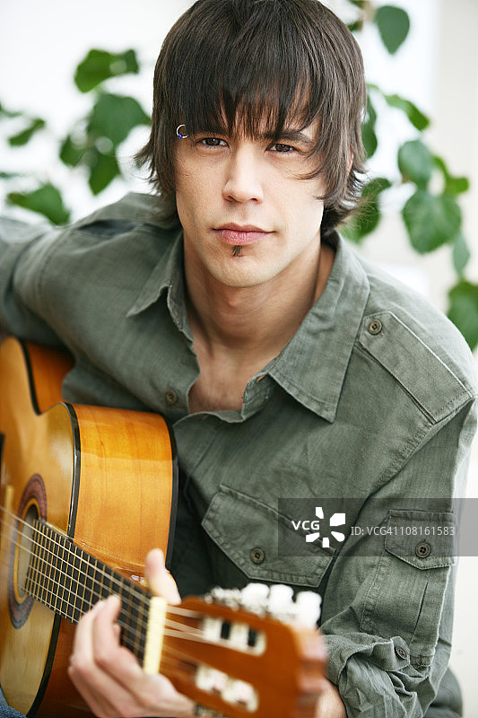 年轻男人弹奏原声吉他图片素材