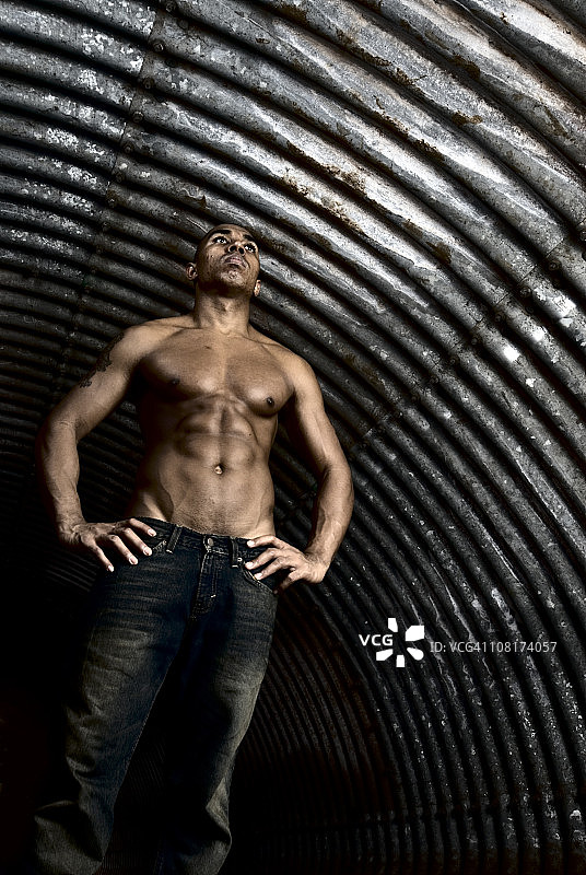 赤膊的年轻男子在隧道中摆姿势的肖像图片素材