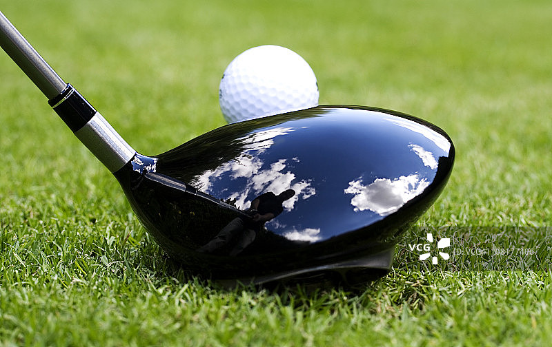 高尔夫球座上的球与球杆中高尔夫球手的倒影图片素材