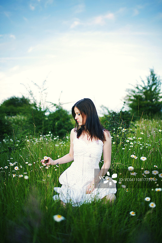 穿白色连衣裙的女人在花田图片素材