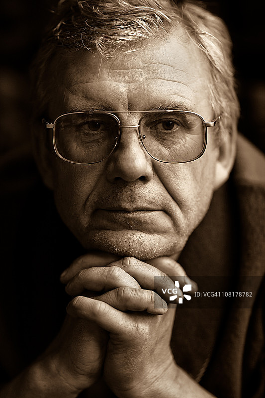 棕褐色调的老年男人手扶下巴图片素材