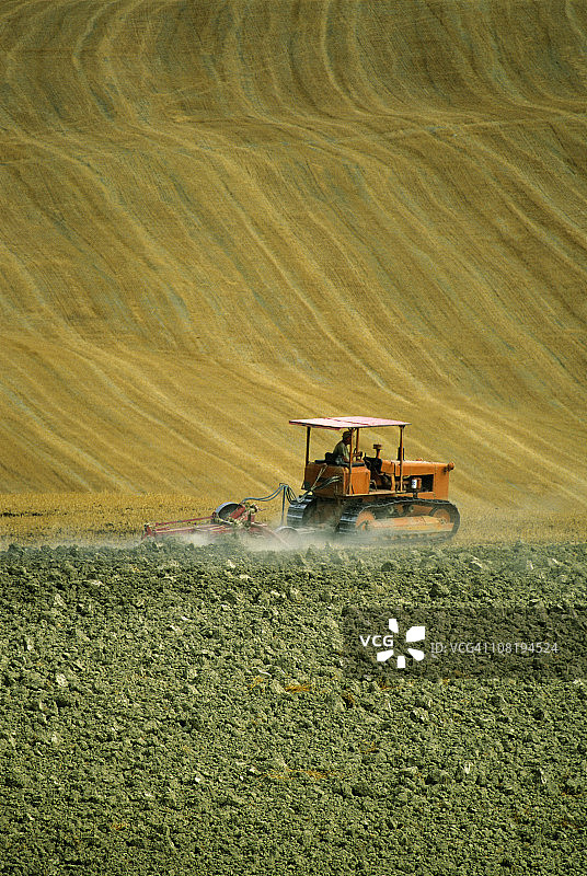 拖拉机犁耕金色的田野图片素材