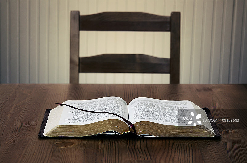 空椅子前桌子上放着的打开的圣经图片素材