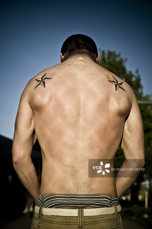 男人展示健壮的背部和纹身图片素材