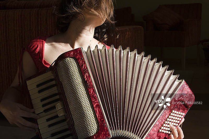 女子演奏红色复古手风琴特写图片素材