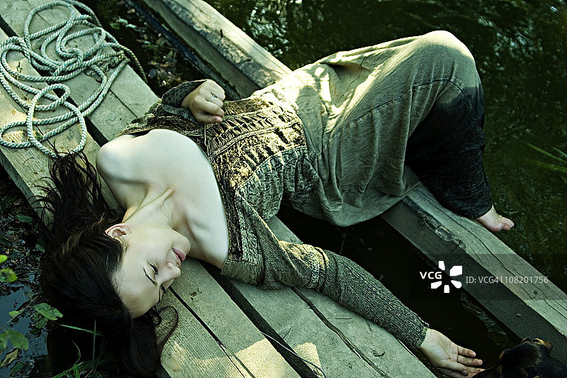 在池塘边的年轻女人图片素材