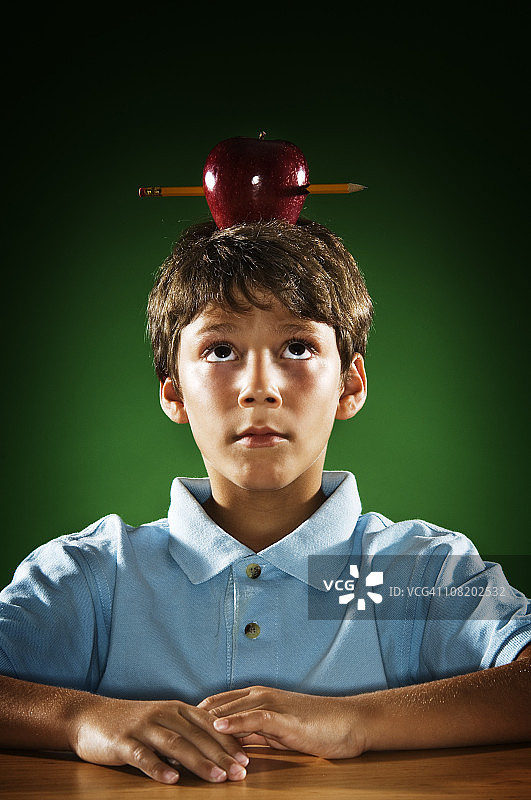头顶苹果保持平衡的小男孩图片素材