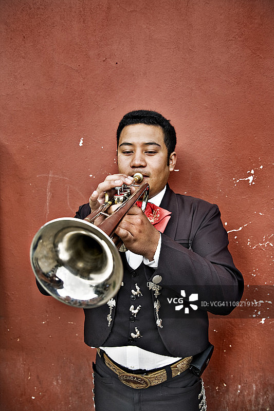 墨西哥流浪乐队男子在墙边吹小号图片素材