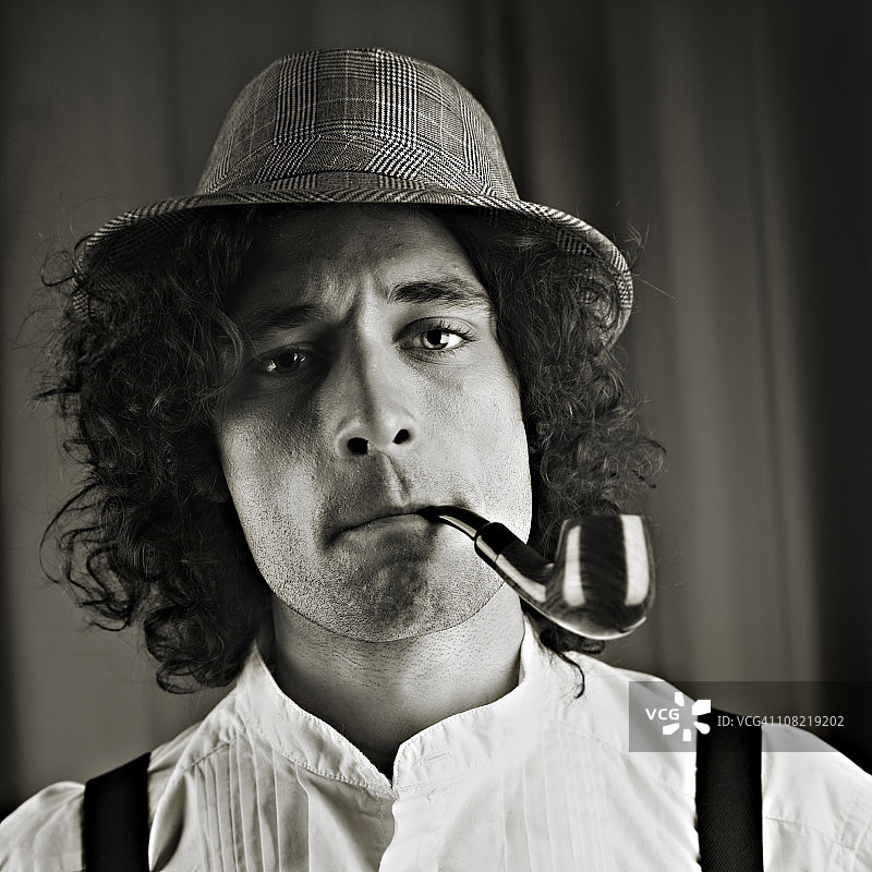 戴帽子抽烟斗的年轻男人（黑白照片）图片素材