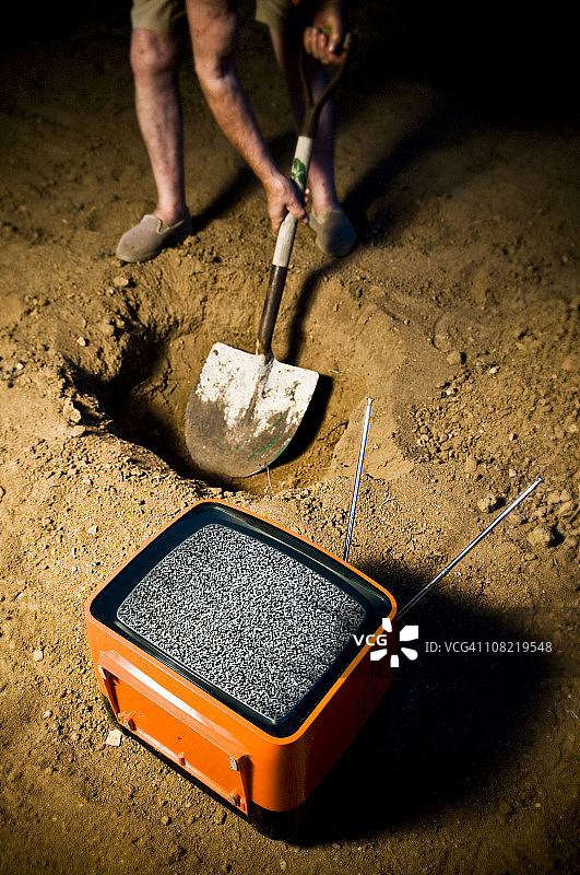 旧电视旁挖洞的人图片素材