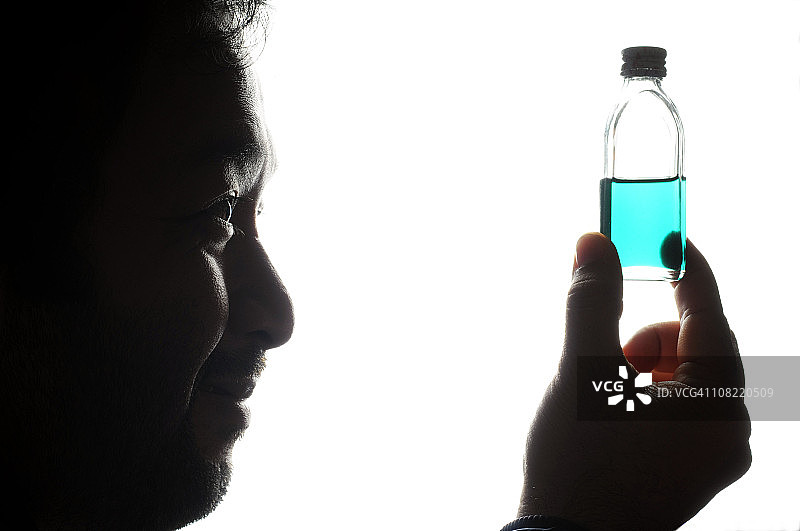 拿着蓝色液体的微笑男人图片素材