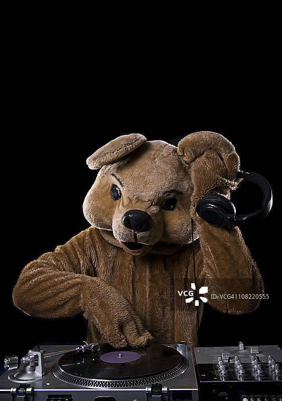 穿熊服装的DJ与唱机耳机图片素材