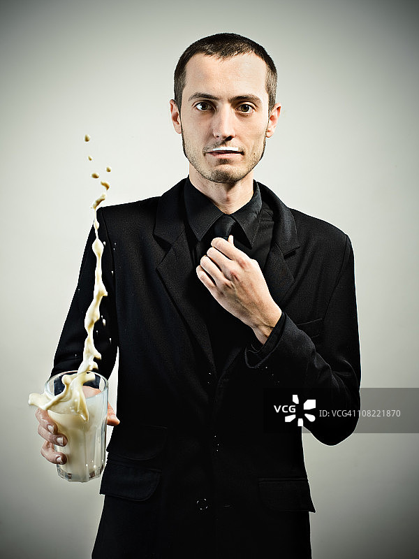 身穿黑色衣服的青年男子扔牛奶杯图片素材