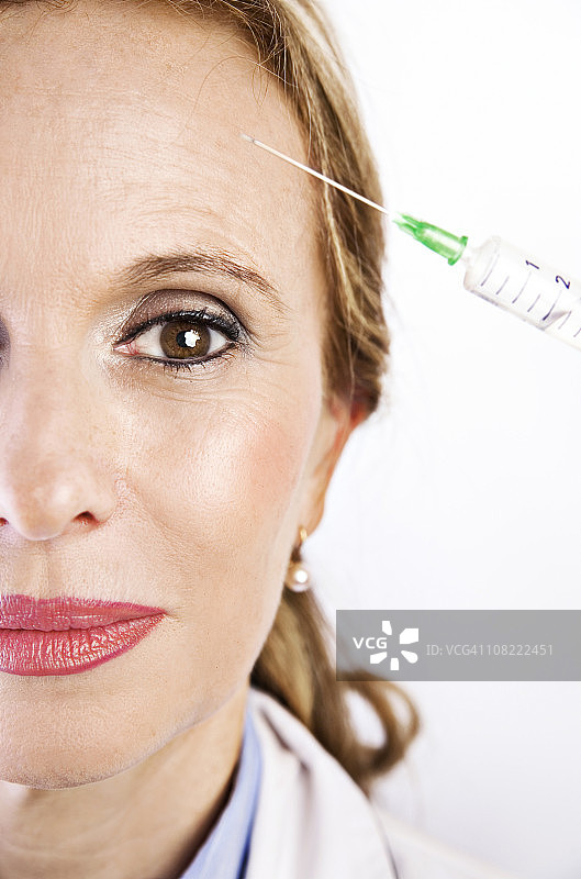 女人接受额头注射肉毒杆菌图片素材