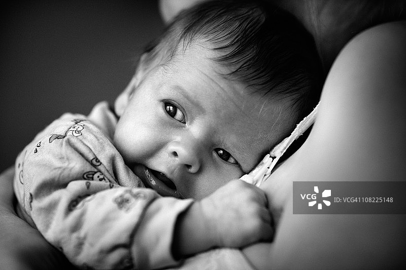 黑白肖像：躺在母亲身上的男婴图片素材