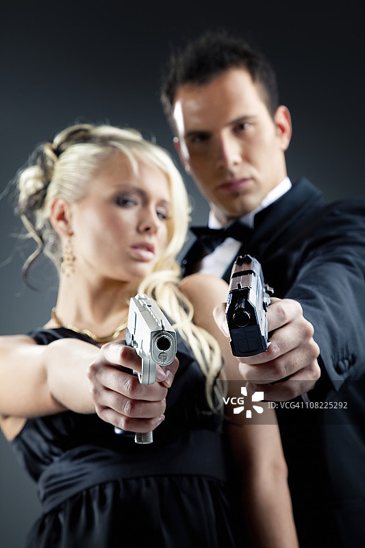 穿着燕尾服的英俊男人和拿着枪的女人图片素材