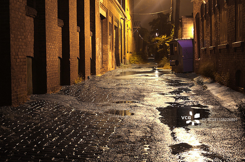 夜晚有水坑的城市小巷图片素材