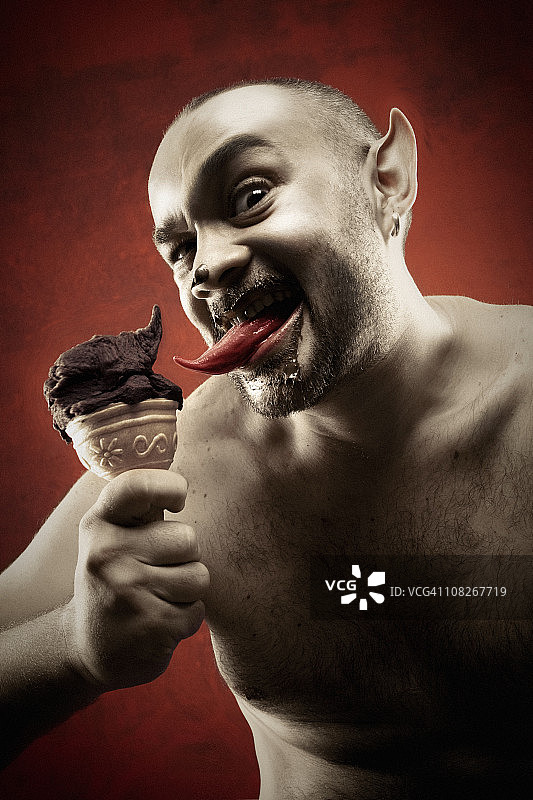 没穿衬衫的恶魔舔着冰淇淋甜筒图片素材