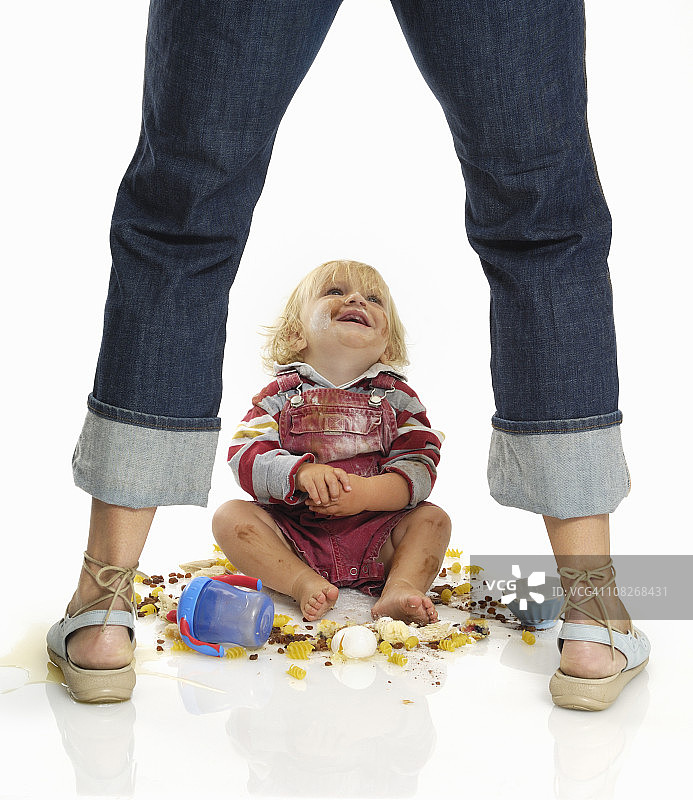 幼儿抬头看着妈妈，弄得一团糟图片素材