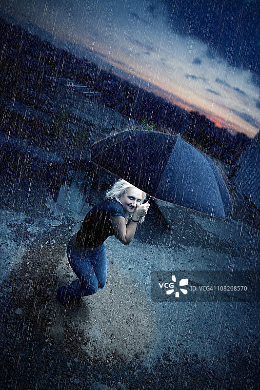 在雨中撑伞的金发美女图片素材