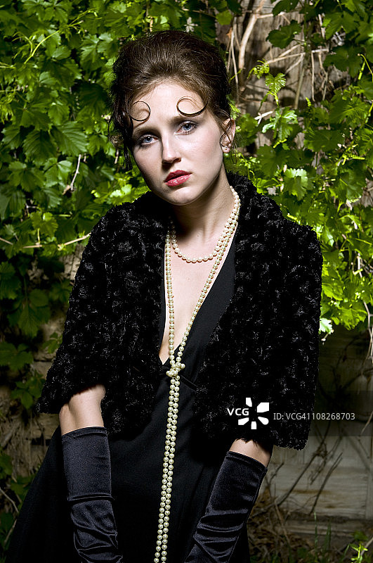 穿着黑色连衣裙和长手套的时髦女郎图片素材