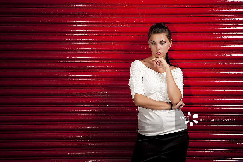 靠在红墙上的愠怒女孩图片素材