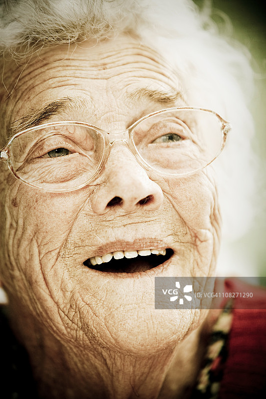 戴眼镜的微笑老年妇女肖像图片素材