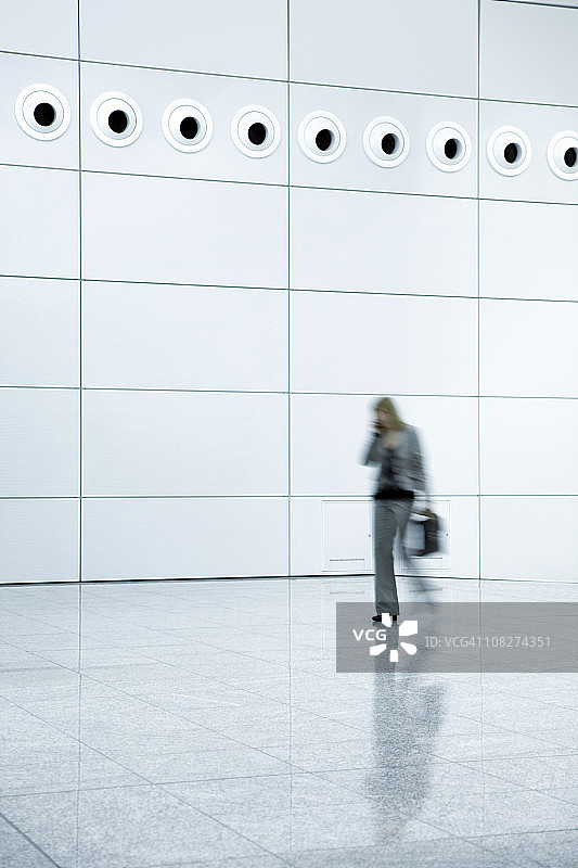 在现代办公楼里走动的女商人图片素材