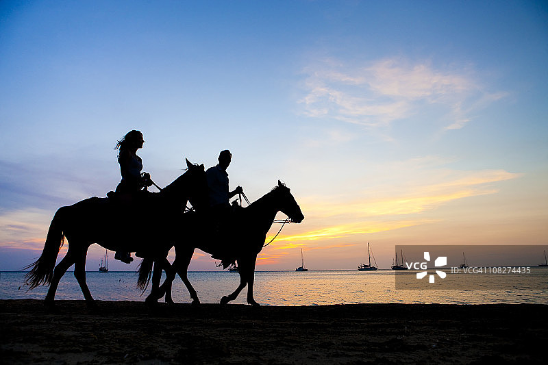 度假生活方式 - 夫妇在日落时骑马图片素材