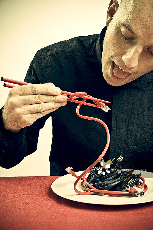 男子用筷子吃电缆图片素材